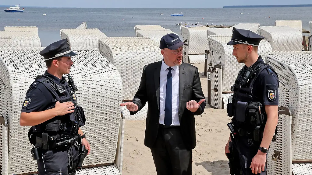 Innenminister-Christian-Pegel-SPD-M-unterhaelt-sich-im-Strandbad-Ueckermuende-mit-zwei-Polizisten
