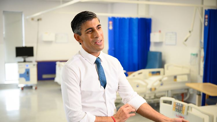 Die Regierung in London will mit Sparen und Steuererhöhungen ein Haushaltsloch von 40 Milliarden in ein Plus verwandeln: Premier Sunak krempelt beim Ortstermin in einem Krankenhaus schon mal die Ärmel hoch.