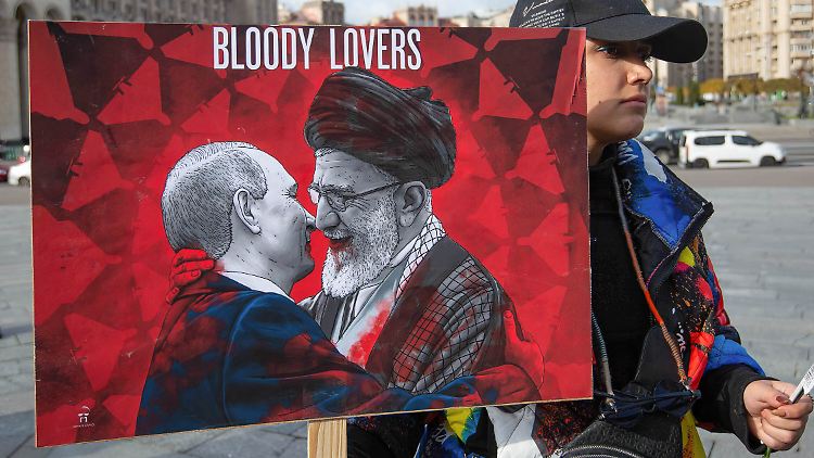 Der russische Präsident Putin und Ali Chamenei, "Oberster Führer" des Iran, sind diesem Demonstranten zufolge "Blutige Liebhaber".