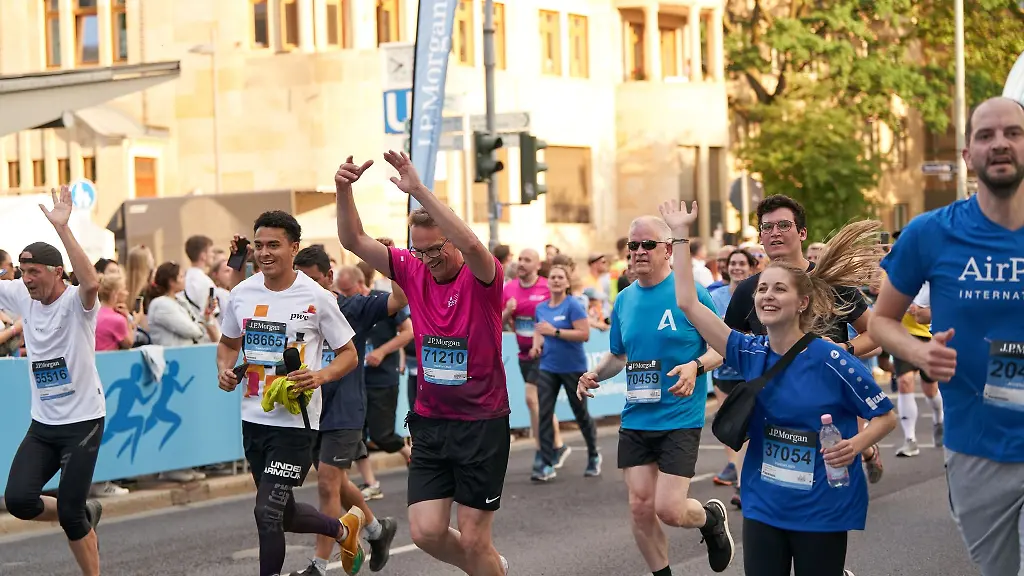 Teilnehmer-der-J-P-Morgan-Corporate-Challenge-passieren-nach-5-7-Kilometern-langen-Weg-durch-die-Frankfurter-Innenstadt-die-Ziellinie