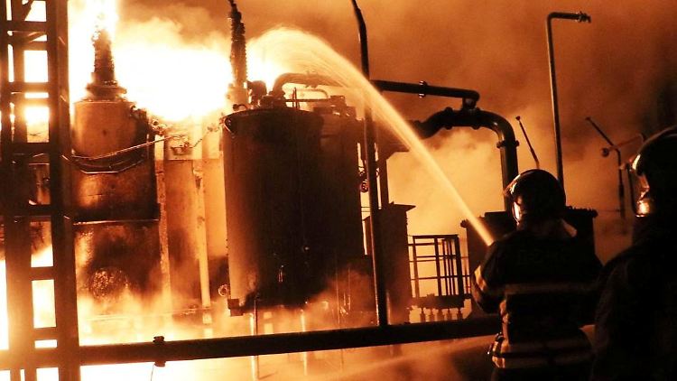 Feuerwehrleute löschen ein Feuer in einer Energie-Infrastruktur-Anlage, die durch einen russischen Drohnenangriff beschädigt wurde.