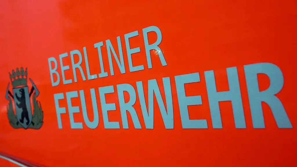 Der-Schriftzug-Berliner-Feuerwehr-und-das-Wappen-Berliner-Feuerwehr-mit-dem-Berliner-Baeren-stehen-auf-der-Tuer-eines-Feuerwehrfahrzeuges