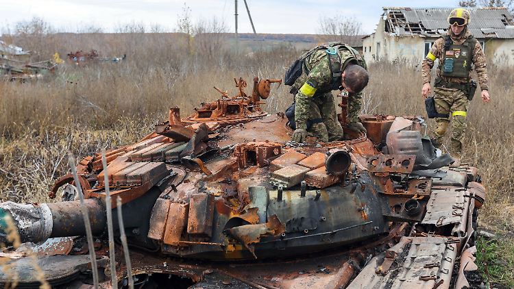 Ukrainische Soldaten auf einem ausgebrannten russischen Panzer in der Region Charkiw.