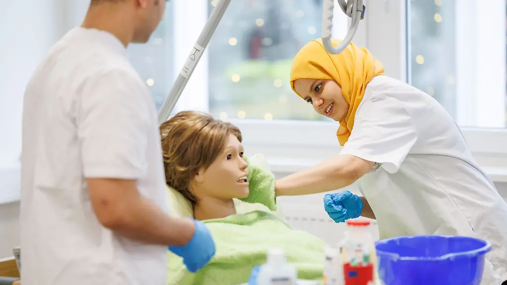 Die-Pflegefachkraefte-in-Anerkennung-Emad-Hashem-aus-Aegypten-l-r-und-Kaouther-Toumi-aus-Tunesien-nehmen-an-einem-Praxistraining-zur-Koerperpflege-teil