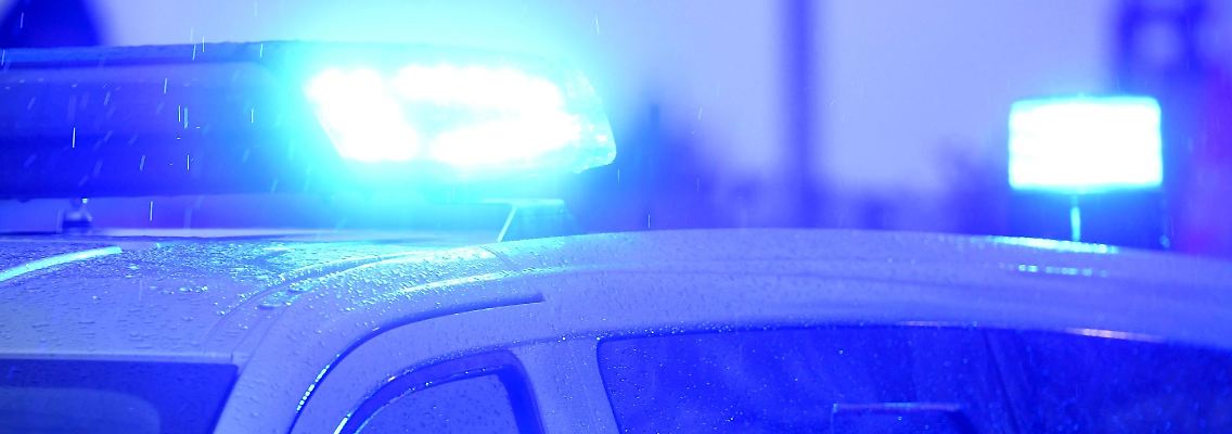 Blaulichter leuchten auf dem Dach eines Polizeifahrzeugs.