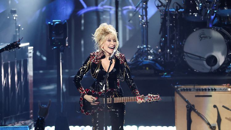 Auf einer kristallbesetzten E-Gitarre spielend, stellte Parton ihren neuen Rocksong vor.