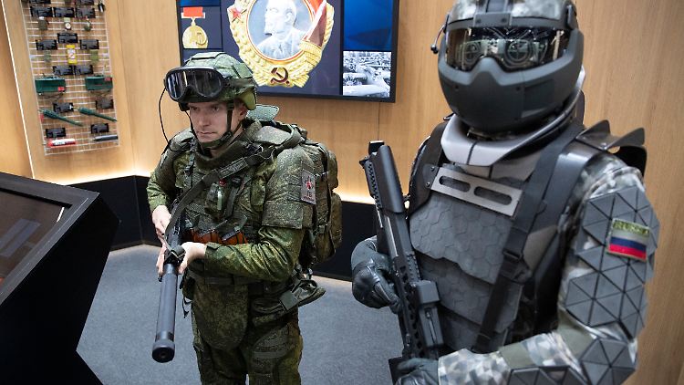Ein Soldat neben einem russischen Prototyp eines Exoskeletts. 