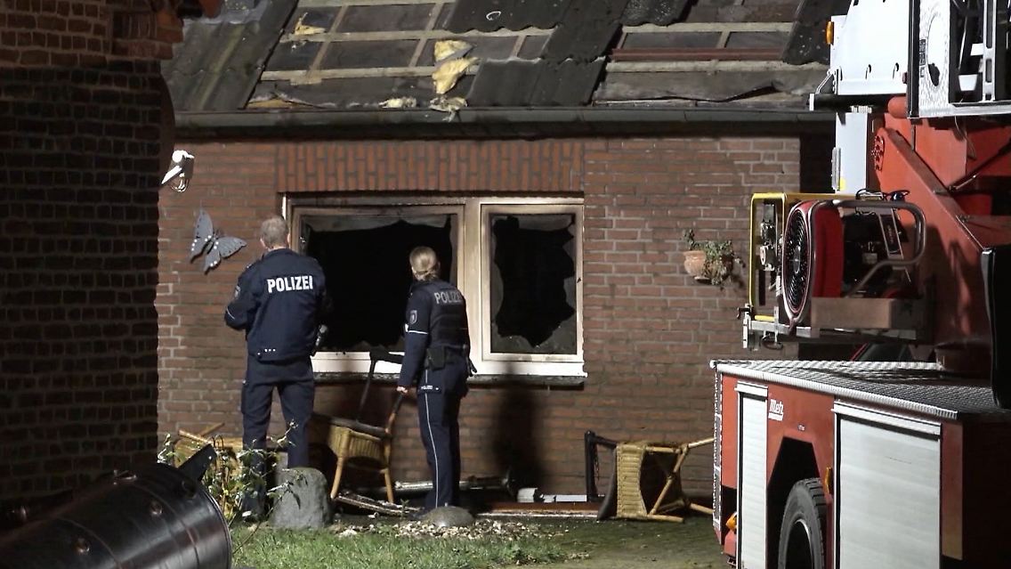 Zwei Polizisten inspizieren den Brandort.