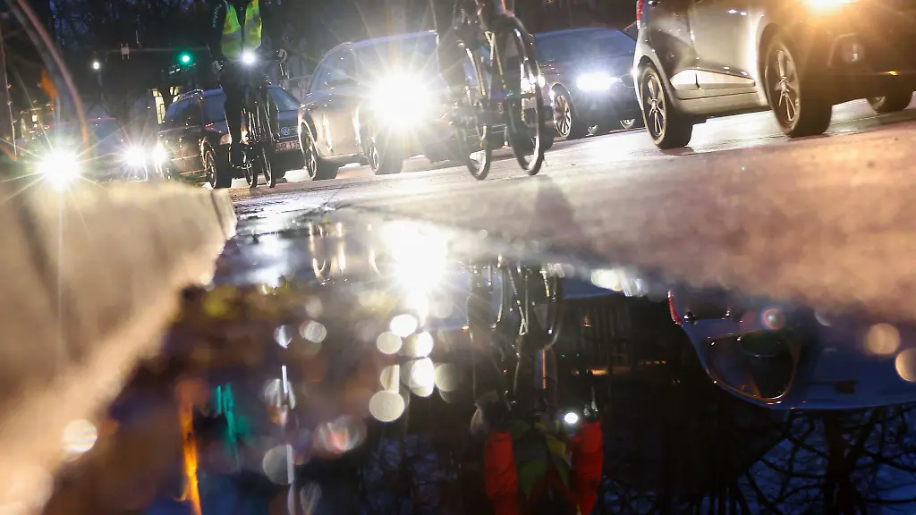 Verkehrsteilnehmerinnen-und-Verkehrsteilnehmer-sind-am-Morgen-auf-der-Radspur-einer-Hauptverkehrsstrasse-in-der-Innenstadt-unterwegs