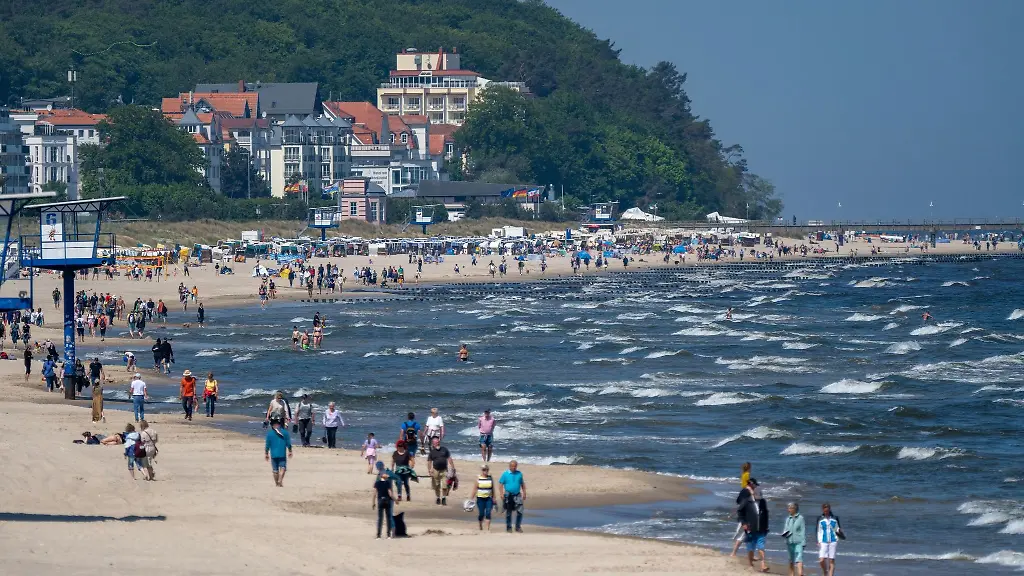 Spaziergaenger-sind-bei-sonnigem-Wetter-am-Strand-auf-der-Insel-Usedom-unterwegs