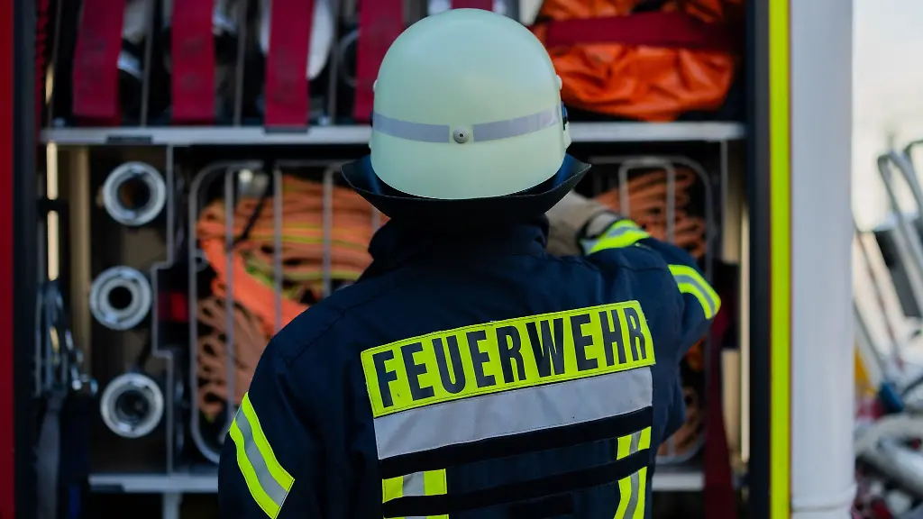 Ein-Feuerwehrmann-holt-Equipment-aus-einem-Einsatzfahrzeug