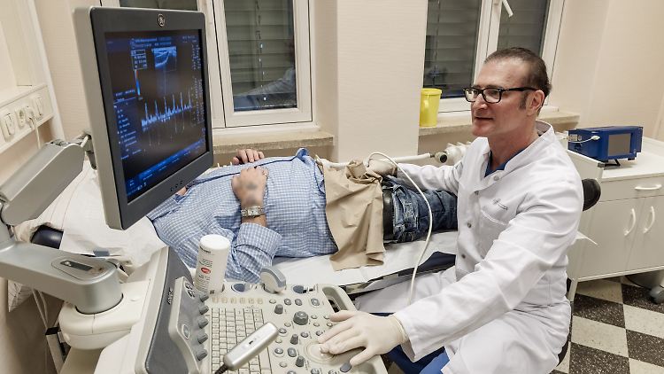 Urologe Frank Sommer untersucht den Penis eines Patienten mit einem Ultraschallgerät. Veränderungen der Blutgefäße können hier einen drohenden Herzinfarkt bereits Jahre vorher anzeigen.