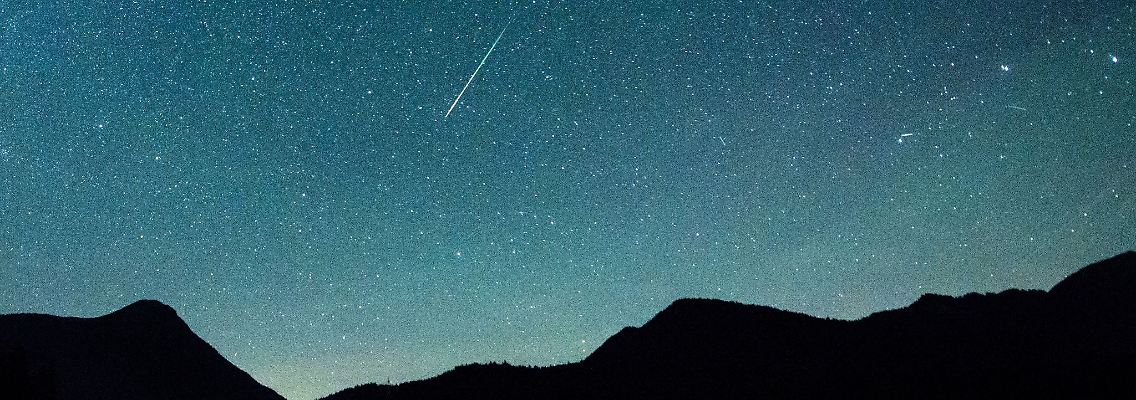 Eine Sternschnuppe leuchtet neben der Milchstraße am Himmel über dem Walchensee.jpg