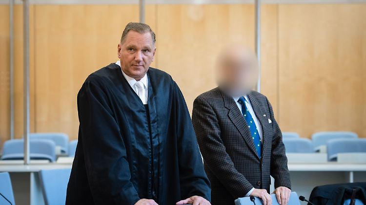 Der Angeklagte (r.) steht vor der Urteilsverkündung im Gerichtssaal.