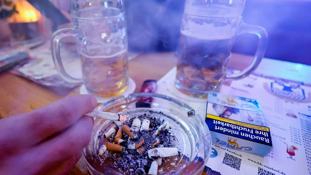 Ein-Mann-ascht-in-einer-Raucherkneipe-seine-Zigarette-ab