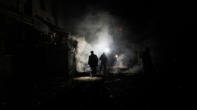 Anwohner gehen nach einem Angriff durch die Trümmer in Cherson.