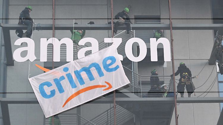 In München befestigte die Umweltorganisation Greenpeace ein Protestbanner an der deutschen Amazon-Zentrale.