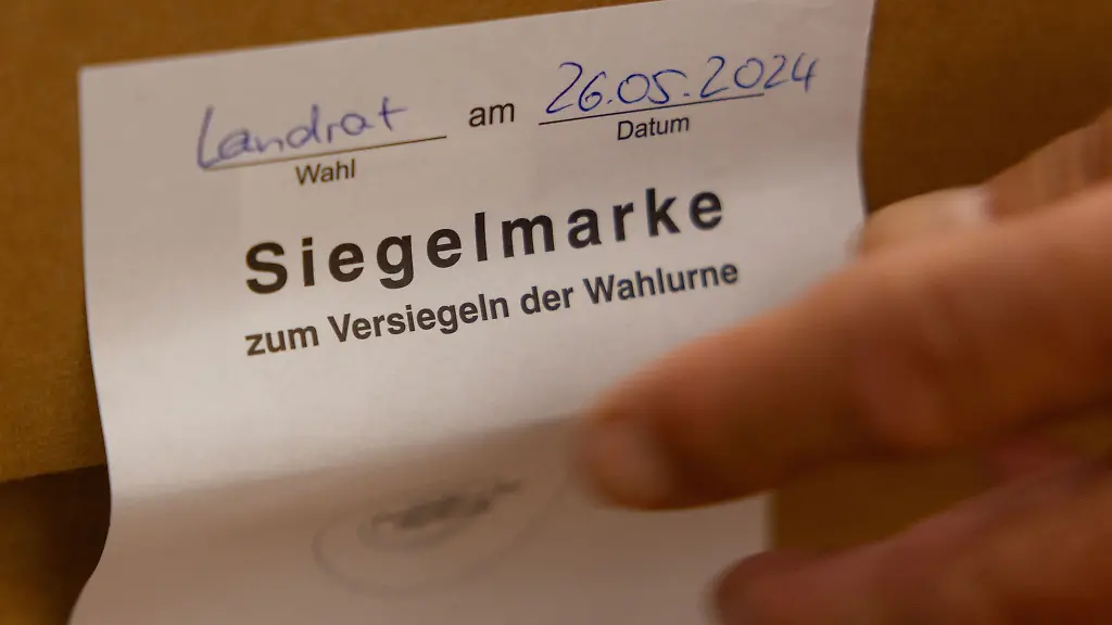 Ein-Wahlhelfer-entfernt-die-Siegelmarke-einer-Wahlurne-zur-Auszaehlung-der-Stimmzettel