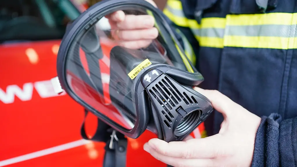 Ein-Feuerwehrmann-haelt-eine-Atemmaske-in-den-Haenden