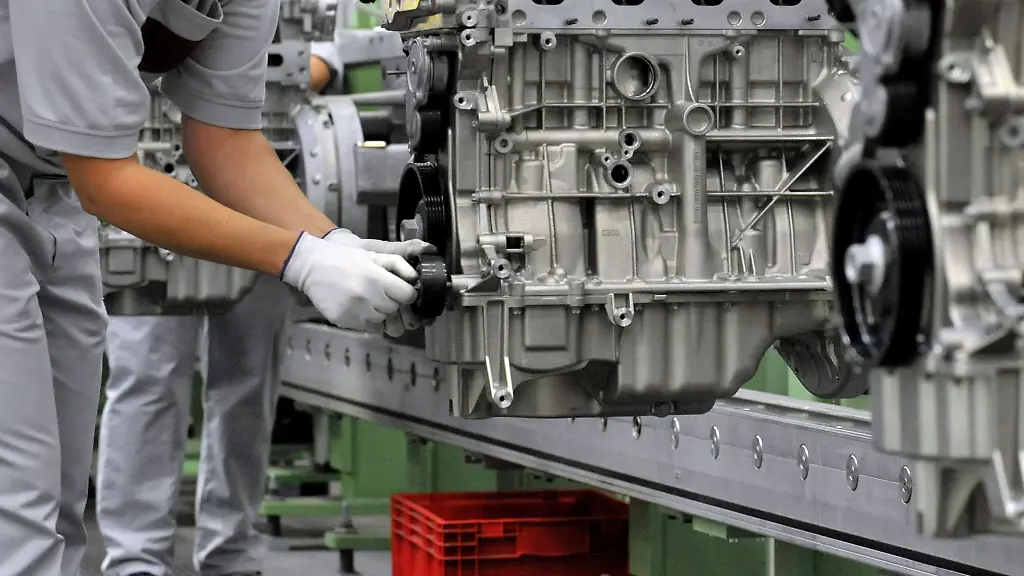 Bei-einem-Automobilzulieferer-montiert-eine-Mitarbeiterin-einen-Vierzylinder-Benzinmotor