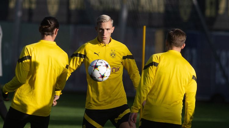 Borussia Dortmunds Nico Schlotterbeck (M) wärmt sich mit dem Ball vor dem Training auf.