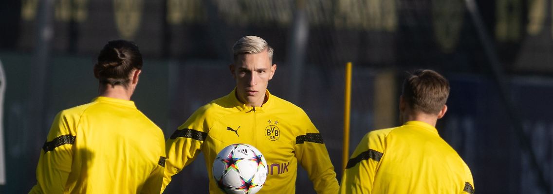 Borussia Dortmunds Nico Schlotterbeck (M) wärmt sich mit dem Ball vor dem Training auf.