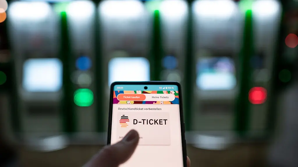 Ein-Mann-haelt-ein-Mobiltelefon-auf-dem-das-D-Ticket-gekauft-werden-kann-in-der-Hand