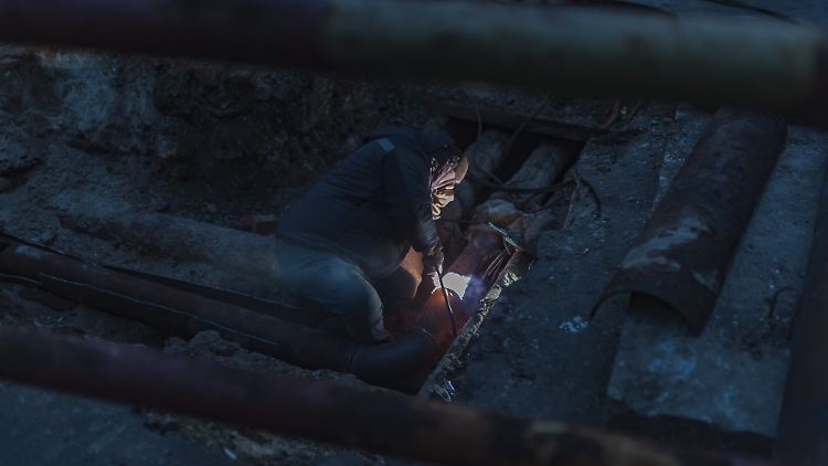 Ein Mann repariert Leitungen in Odessa nach einem Angriff.