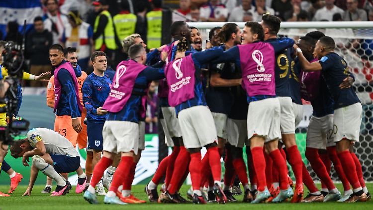 Die französischen Spieler feiern den Sieg, Englands Harry Kane kauert auf dem Rasen.