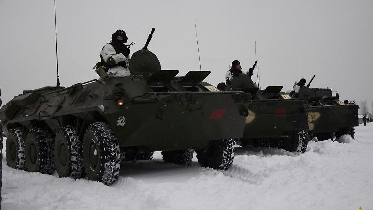 Belarussische Soldaten sitzen auf gepanzerten Mannschaftstransportern an einem unbekannten Ort.