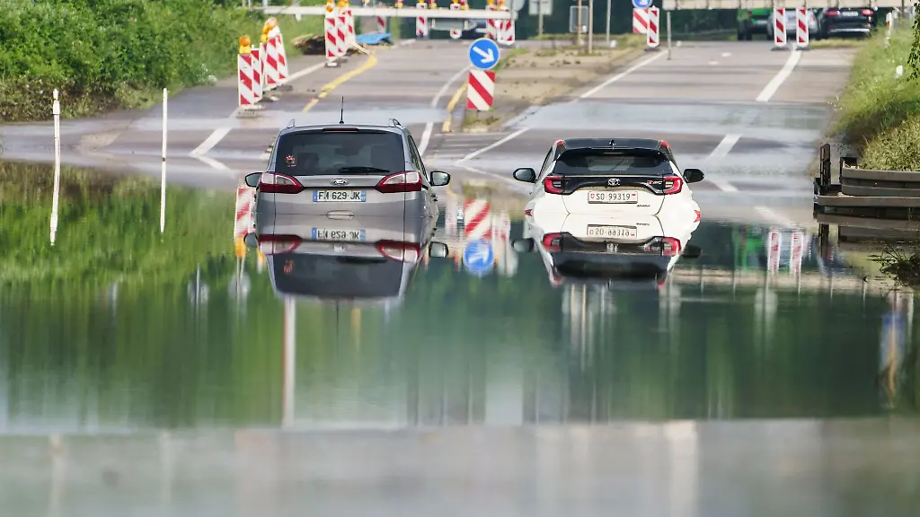 Zwei-Autos-stehen-unter-einer-Saarbruecke-im-Stadtteil-Schoenbach-im-Hochwasser