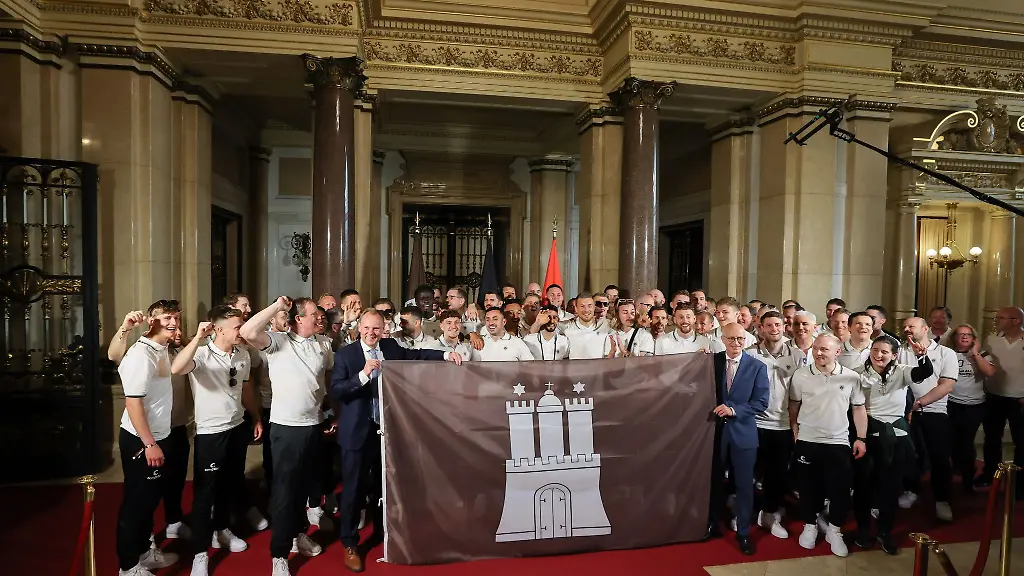 Die-Mannschaft-und-das-Team-des-FC-St-Pauli-stehen-im-Hamburger-Rathaus