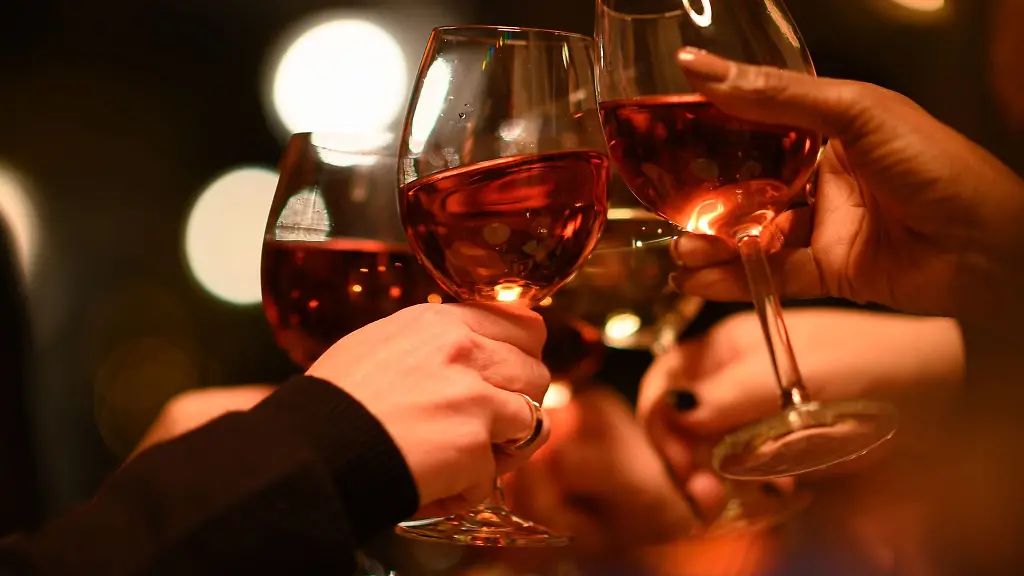 Gaeste-stossen-in-einem-Restaurant-mit-ihren-Weinglaesern-an