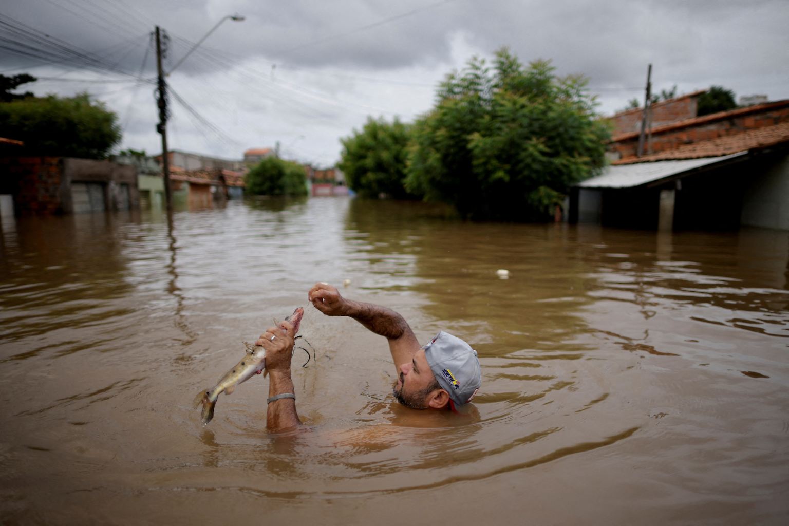 6. Januar: Ein Mann fängt mitten auf einer Straße in Imperatriz einen Fisch. Der Ort im brasilianischen Bundesstaat Maranhão steht nach starken Regenfällen komplett unter Wasser. Immer wieder kommt es 2022 in Brasilien zu teils heftigen Überschwemmungen.