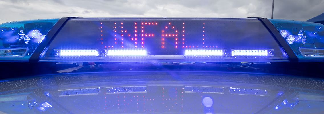 Ein Blaulicht und eine LED-Anzeige leuchten auf dem Dach eines Polizeifahrzeugs.