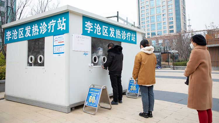 Passanten in Qingdao vor einer Station für "Fieber"-Behandlungen.