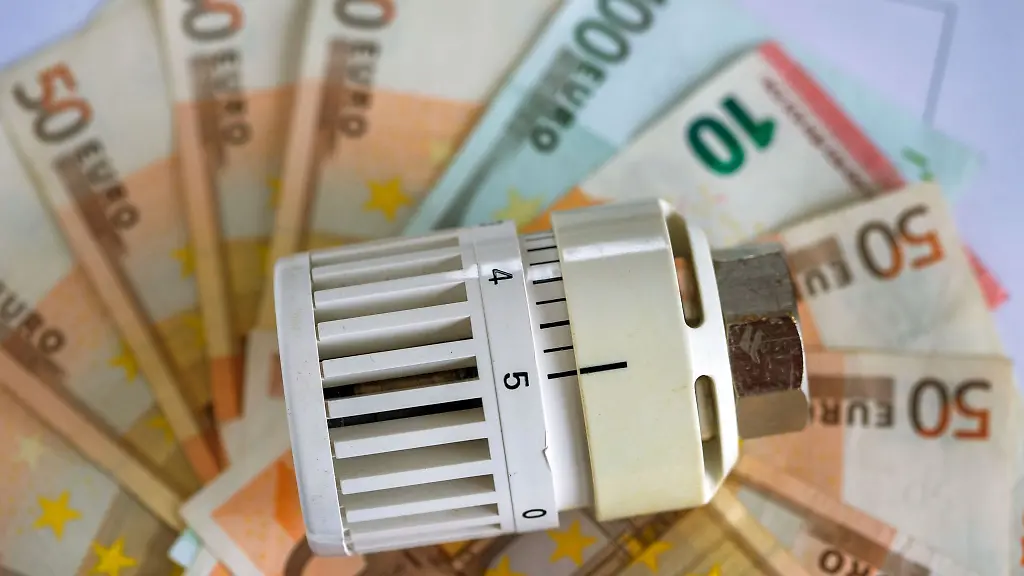 Ein-Heizungsthermostat-und-Geldscheine-liegen-auf-einer-Heizkostenabrechnung