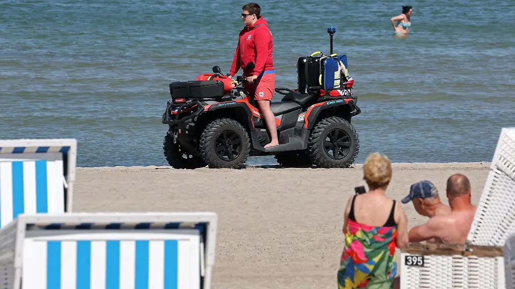 Knut-Bohnow-von-der-DRK-Wasserwacht-ist-mit-dem-Rettungs-Quad-am-Ostseestrand-von-Warnemuende-unterwegs