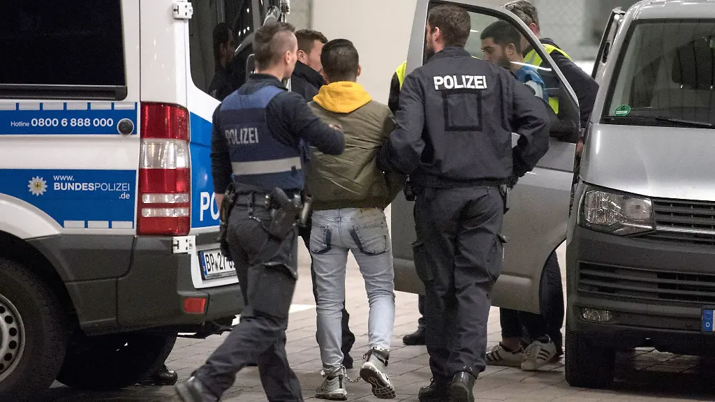 Hand-und-Fussfesseln-traegt-ein-junger-Mann-aus-Afghanistan-den-Polizisten-zur-Abschiebung-zum-Flughafen-bringen