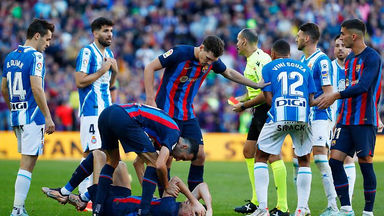 Barcelonas Robert Lewandowski liegt am Boden, während Espanyols Vinicius Souza (M-r) weggeschubst wird, bevor er vom Schiedsrichter eine Rote Karte erhält.