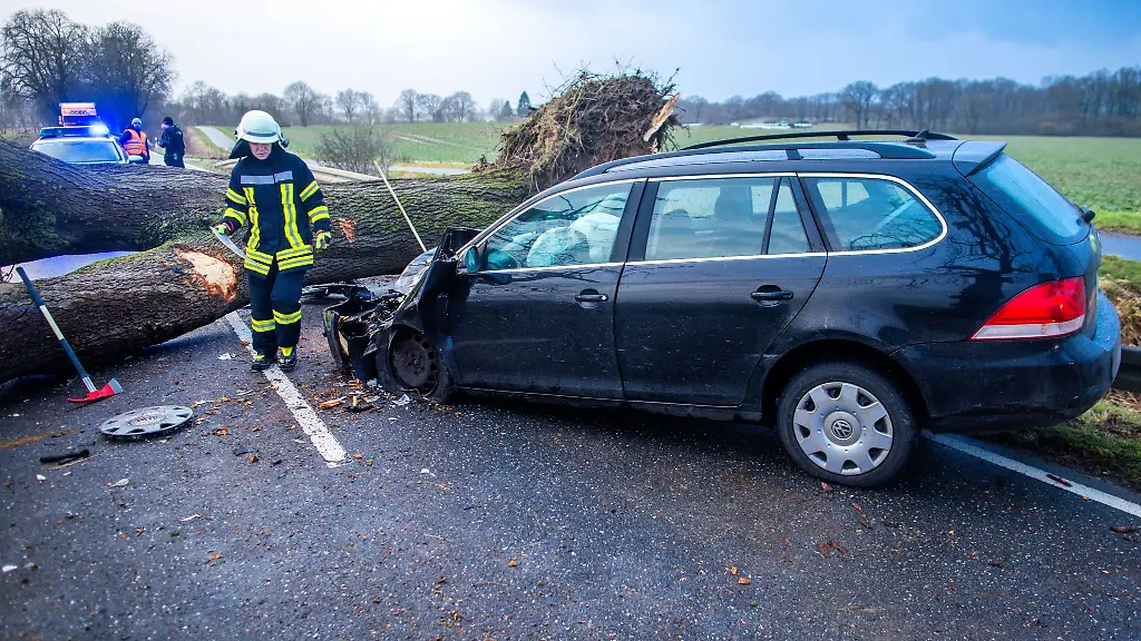Feuerwehrleute-sichern-eine-Unfallstelle-auf-der-Bundestrasse-208-nachdem-ein-PKW-von-einem-durch-Sturm-umstuerzten-Baum-getroffen-wurde