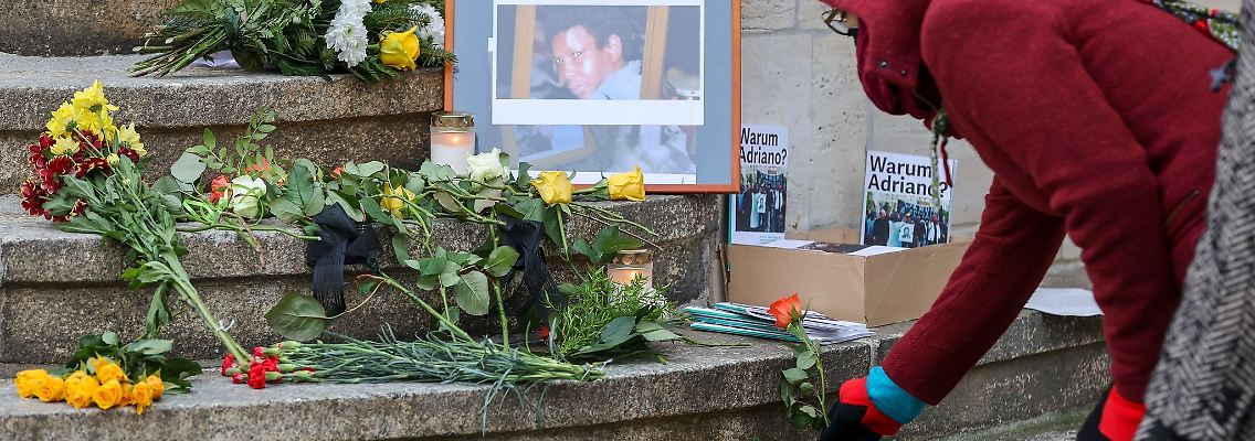 Eine Frau legt eine Rose zum Gedenken an Oury Jalloh auf die Stufen des Polizeireviers.