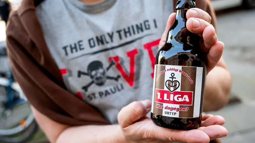 Ein-Fan-haelt-eine-Bierflasche-mit-der-Aufschrift-1-Liga