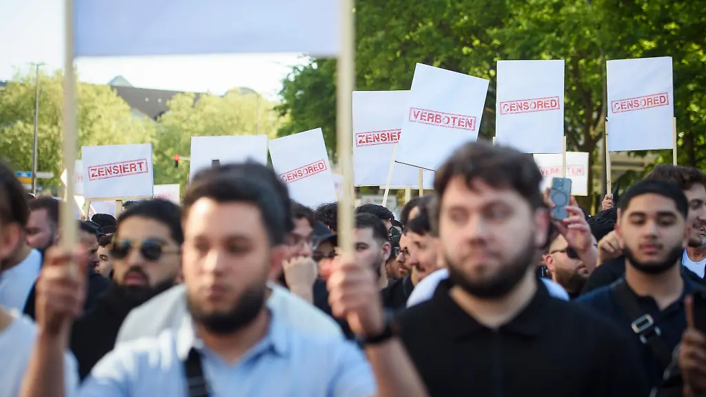 Demonstranten-halten-Schilder-auf-einer-Kundgebung-des-islamistischen-Netzwerks-Muslim-Interaktiv-im-Hamburger-Stadtteil-St-Georg-in-die-Hoehe