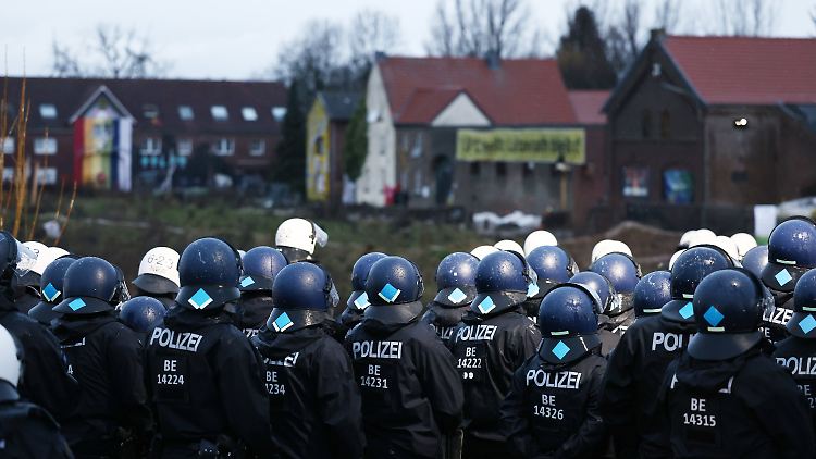 Aktivisten und Polizisten stehen sich am Rande des besetzten Braunkohleorts Lützerath direkt gegenüber.