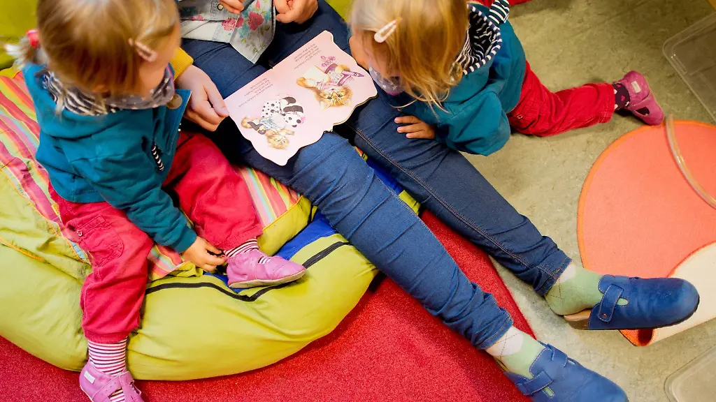 Erzieherin-liest-mit-Zwillingen-ein-Buch