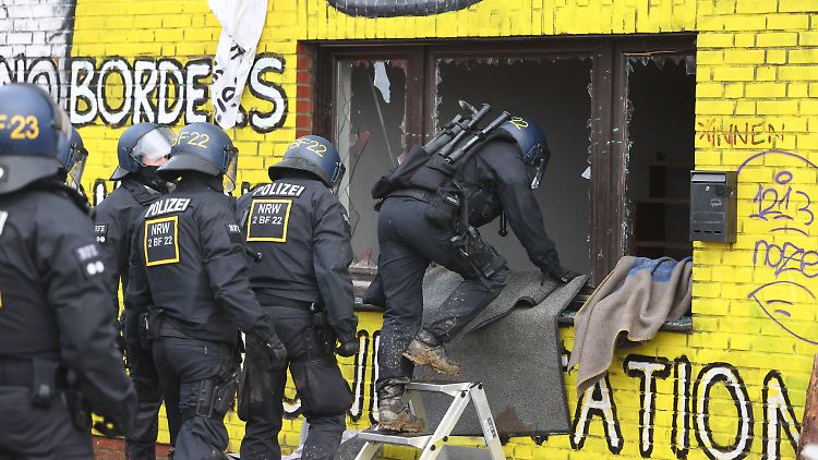 Polizisten steigen in eines der besetzten Häuser in Lützerath ein.