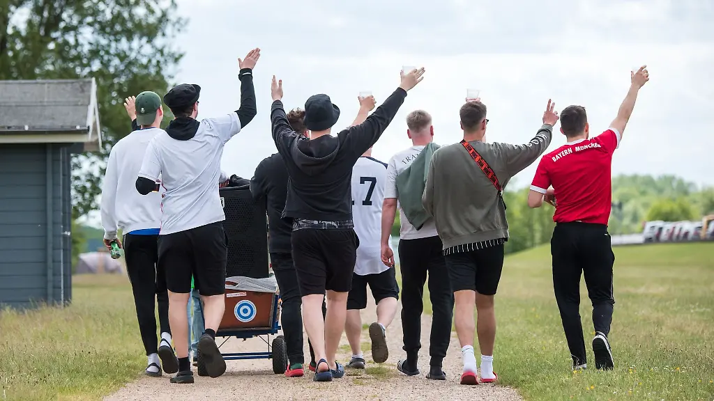Teilnehmer-einer-Vatertagstour-ziehen-am-Feiertag-Christi-Himmelfahrt-mit-einem-Bollerwagen-in-Hamburg-ueber-einen-Wanderweg
