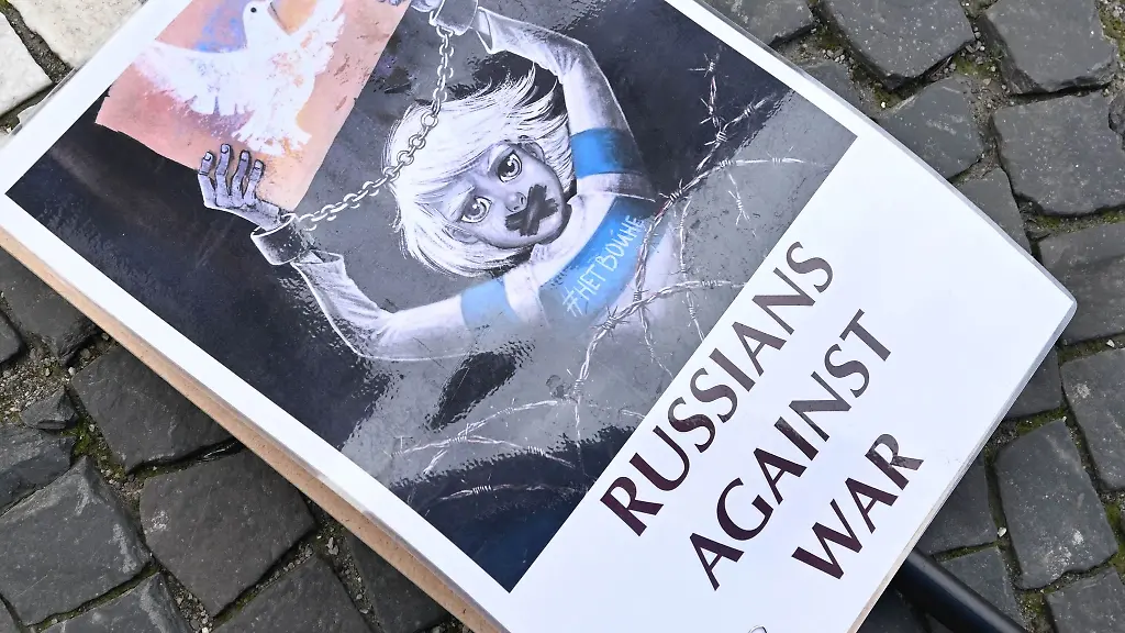 Ein-Schild-mit-der-Aufschrift-Russians-against-war-liegt-auf-dem-Odeonsplatz-in-Muenchen-auf-dem-Boden