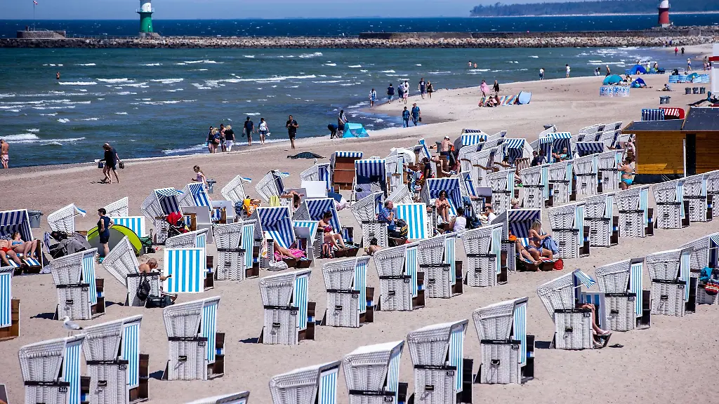 Urlauber-nutzen-das-sonnige-Wetter-zu-einem-Besuch-am-Strand-von-Warnemuende